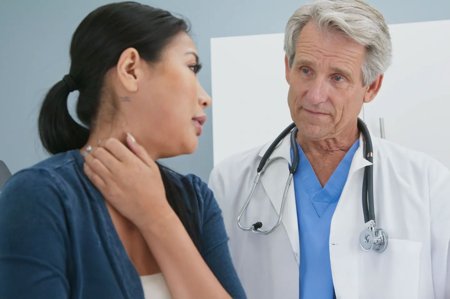 Clinician examining a patient’s shoulder during a consultation, illustrating assessment and evidence-based decision-making in shoulder surgery care