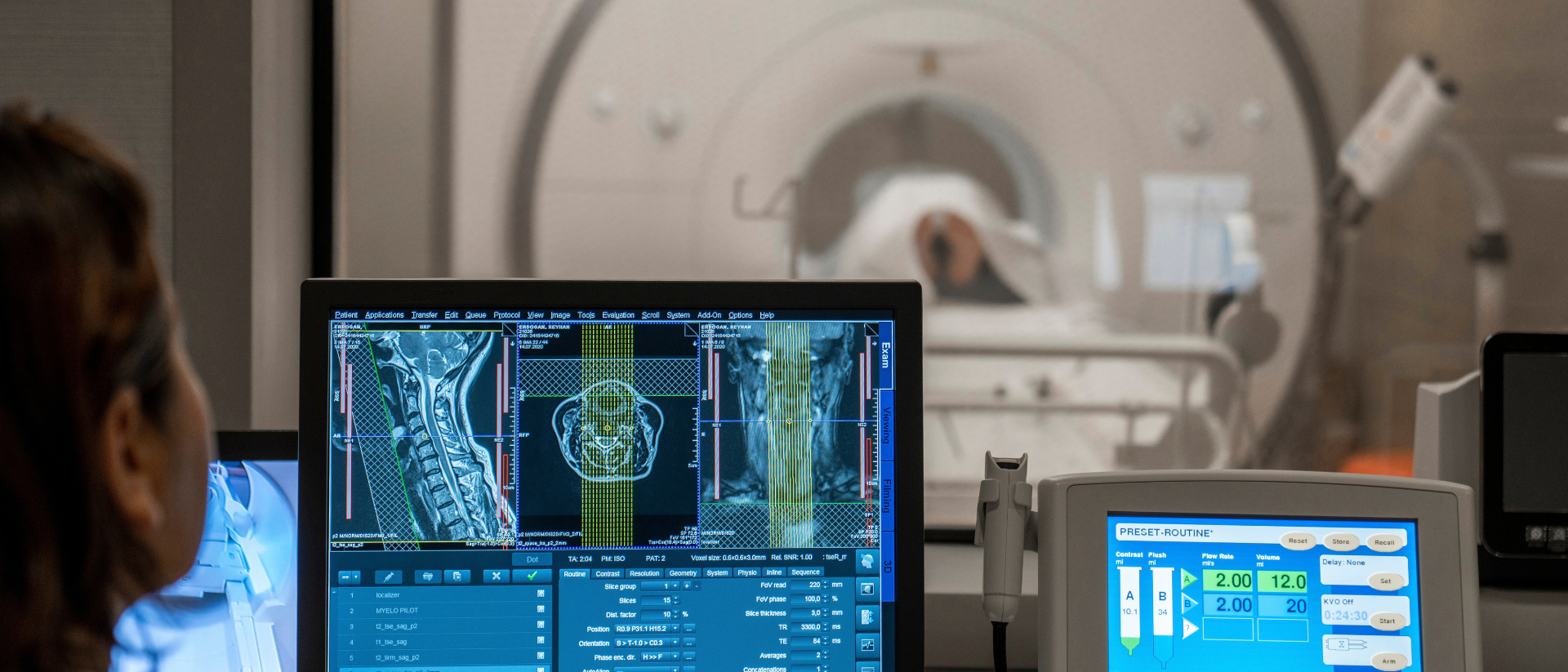 Doctor examining radiology neck scan while patient is in CT machine