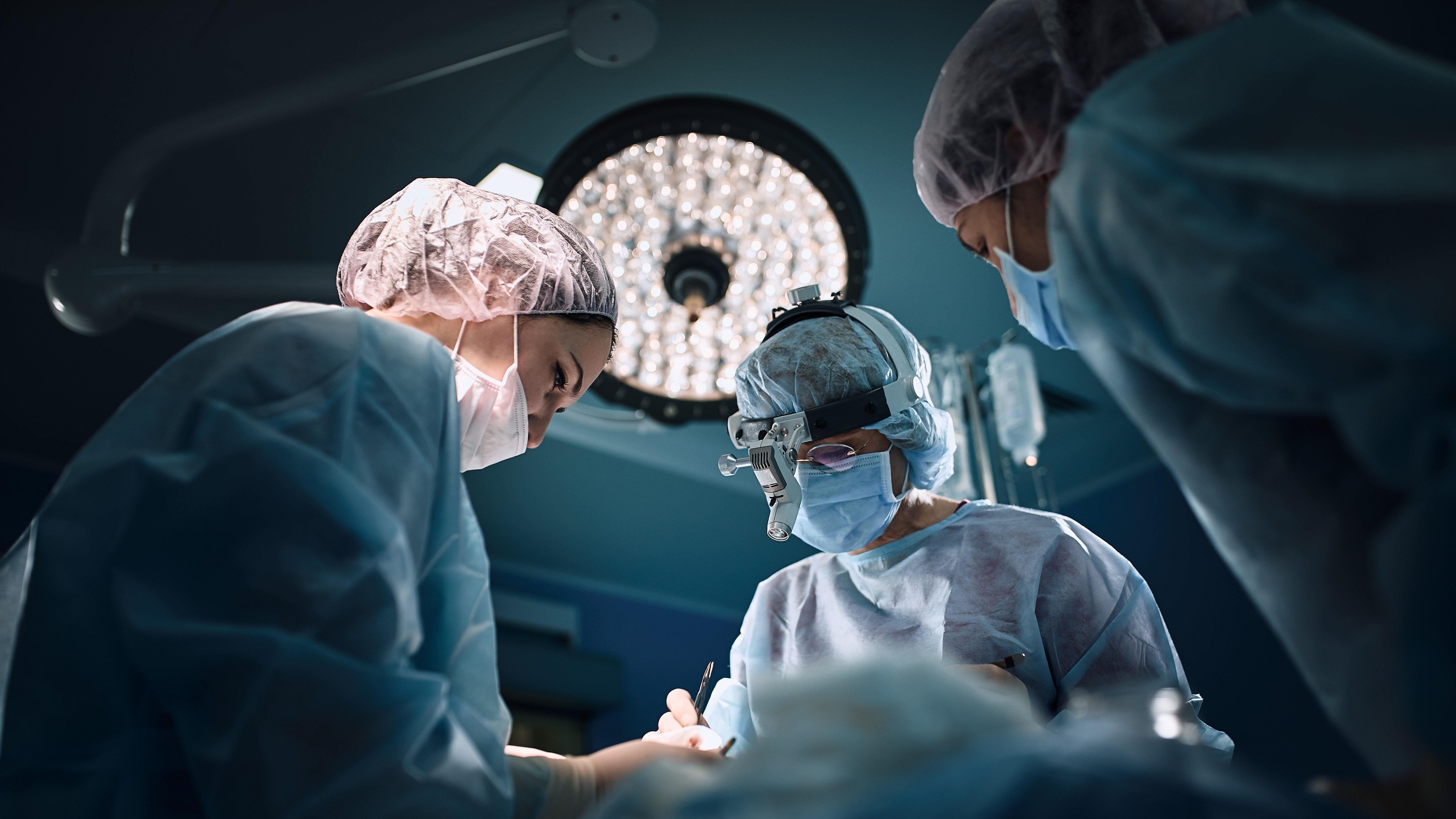 A surgical team performing advanced spine surgery in a modern operating theatre, symbolizing precision, collaboration, and DNV’s focus on patient safety.