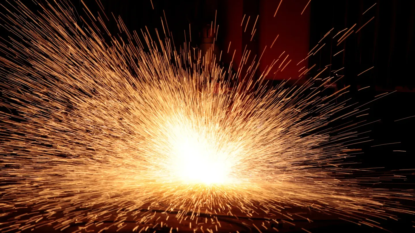 Close-up of welding sparks during fabrication, illustrating welding process quality, safety, and compliance with ISO 3834 standards