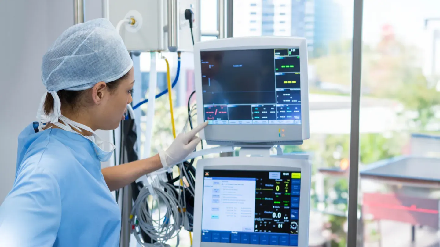 Healthcare professional reviewing a patient monitoring system in a clinical environment, symbolising regulated medical device performance and TCP III compliance