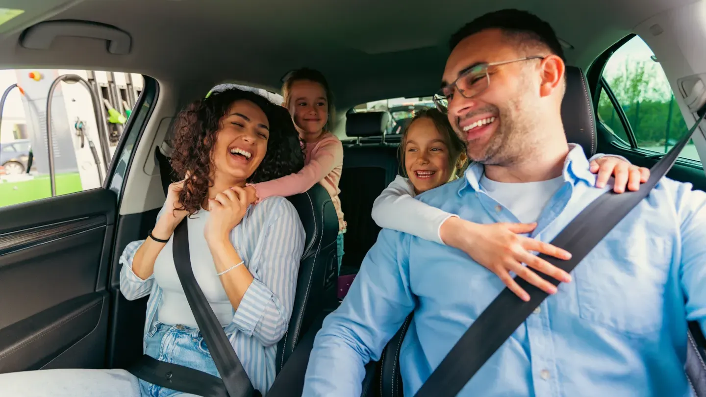 Family seated safely in a car wearing seat belts, illustrating reliable vehicle safety performance