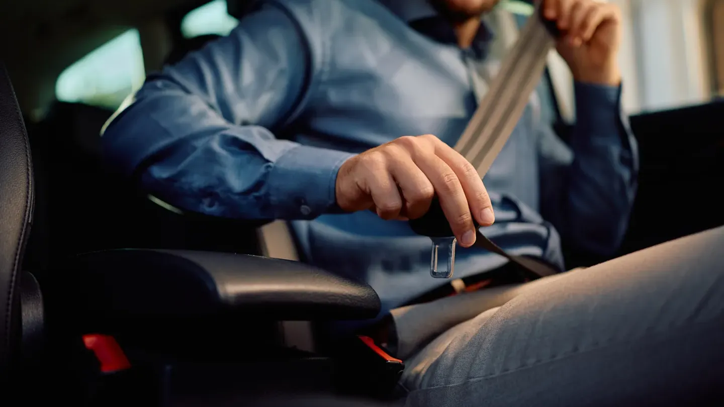 Driver holding the steering wheel in a modern vehicle, representing safe system performance and confidence gained through ISO 26262 certification readiness