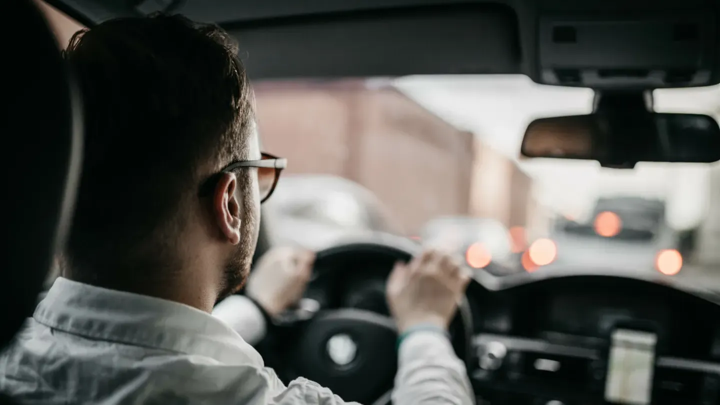 Automotive engineer reviewing in-car system performance while driving, supporting ASPICE-based process development and optimization