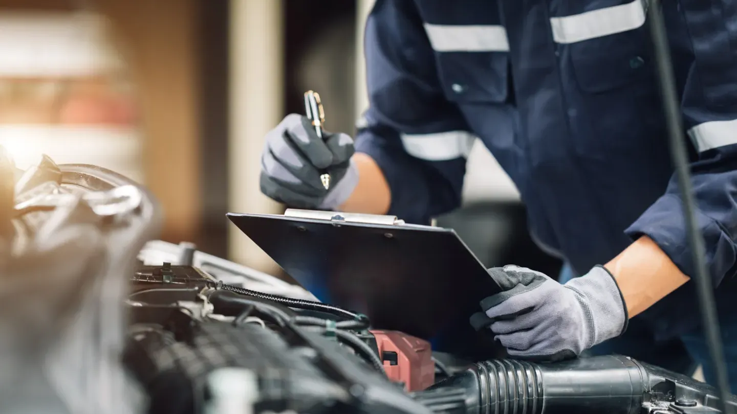 Automotive engineer using a digital tablet to inspect vehicle systems as part of structured safety case development
