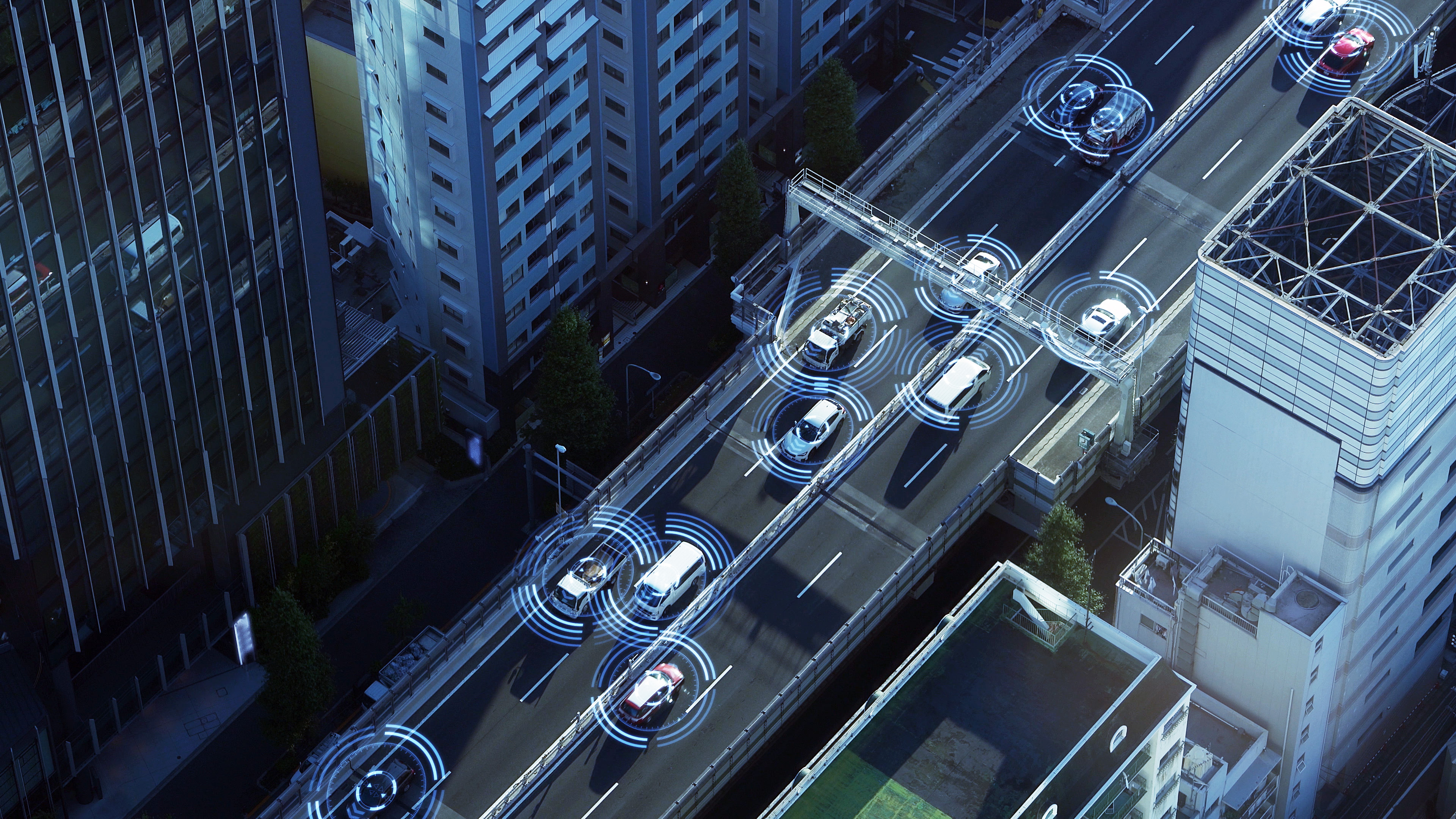 Overhead view of connected cars on a city highway with sensor graphics, illustrating predictive functional safety for automotive systems