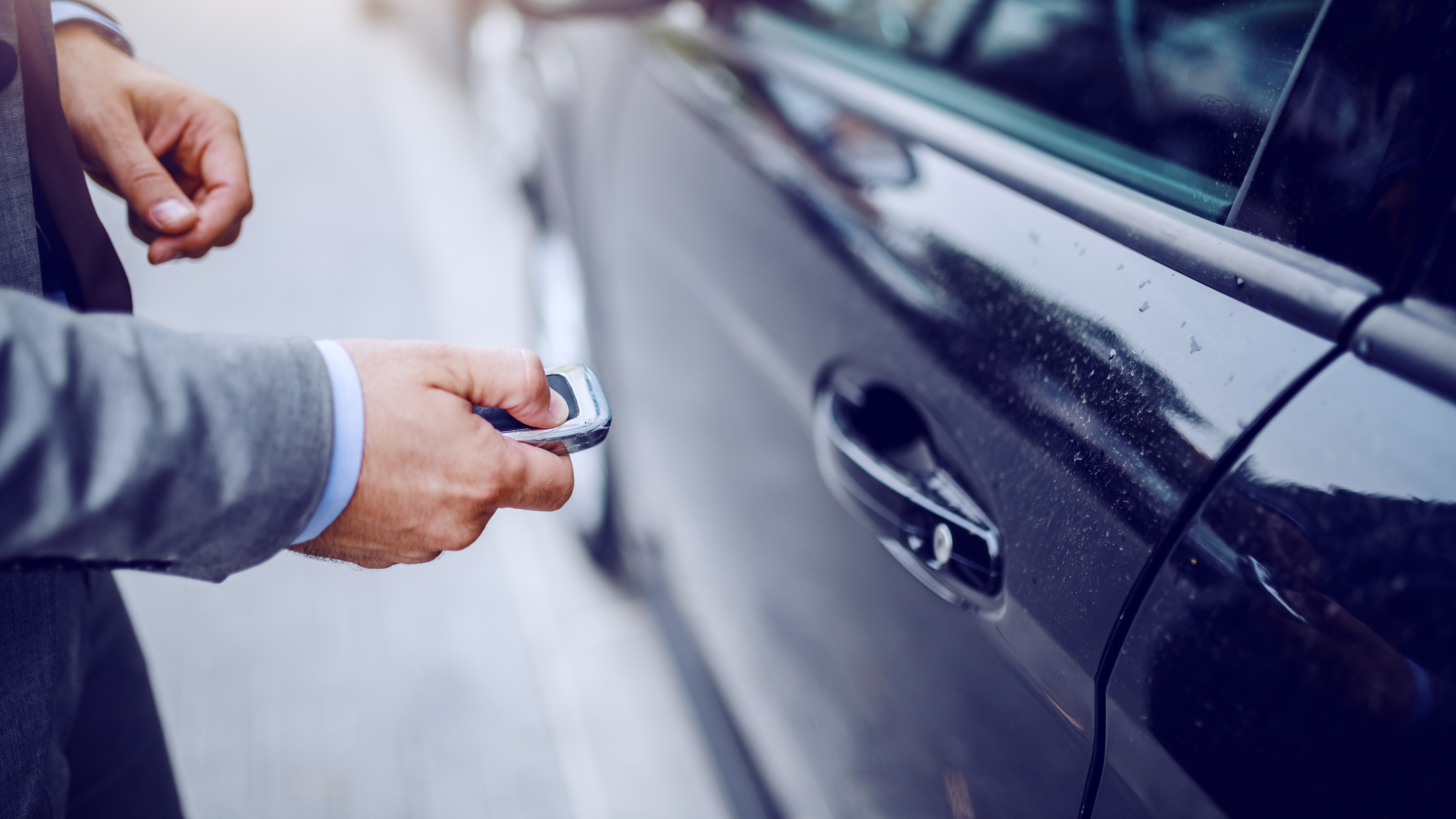 Person opening a car door on a modern vehicle, symbolising driver safety and confidence in automotive safety case development