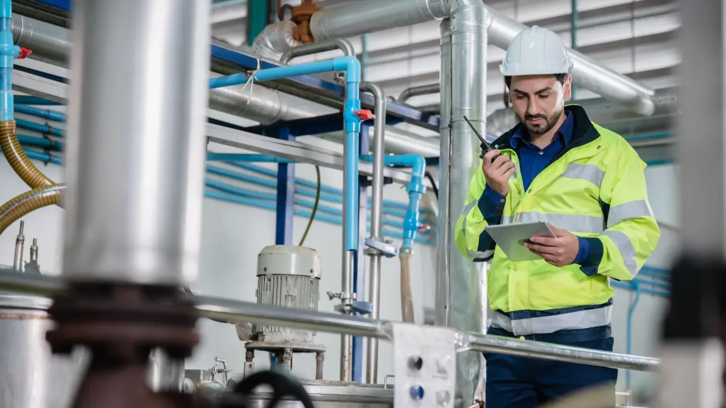 Technician inspecting stainless steel food processing equipment to verify hygiene standards and operational safety