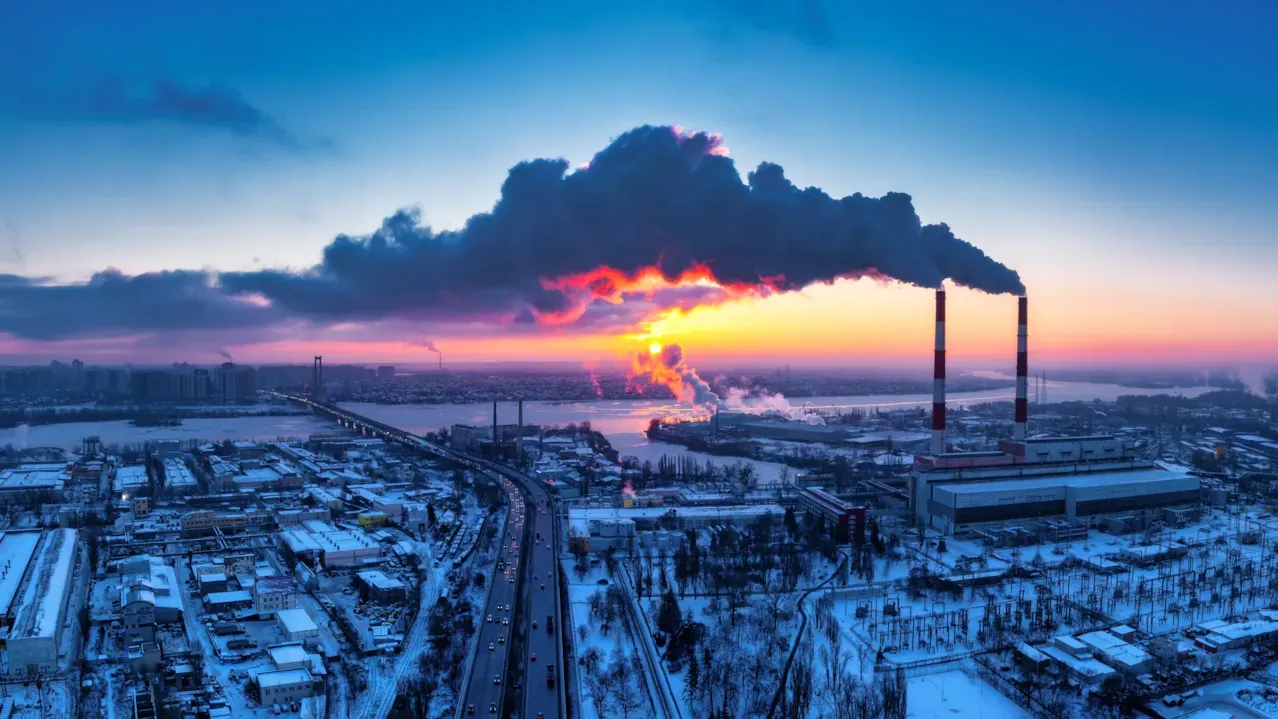 Industrial facility emitting smoke under a sunset sky, illustrating Scope 3 emission hotspots and supply chain decarbonization challenges