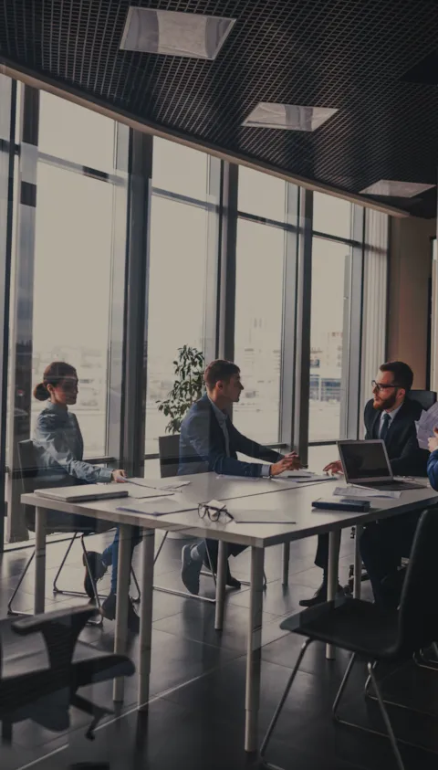 A business team discussing sustainability and risk strategies in a modern office meeting room, representing corporate strategy and decarbonization planning for hard-to-abate sectors.