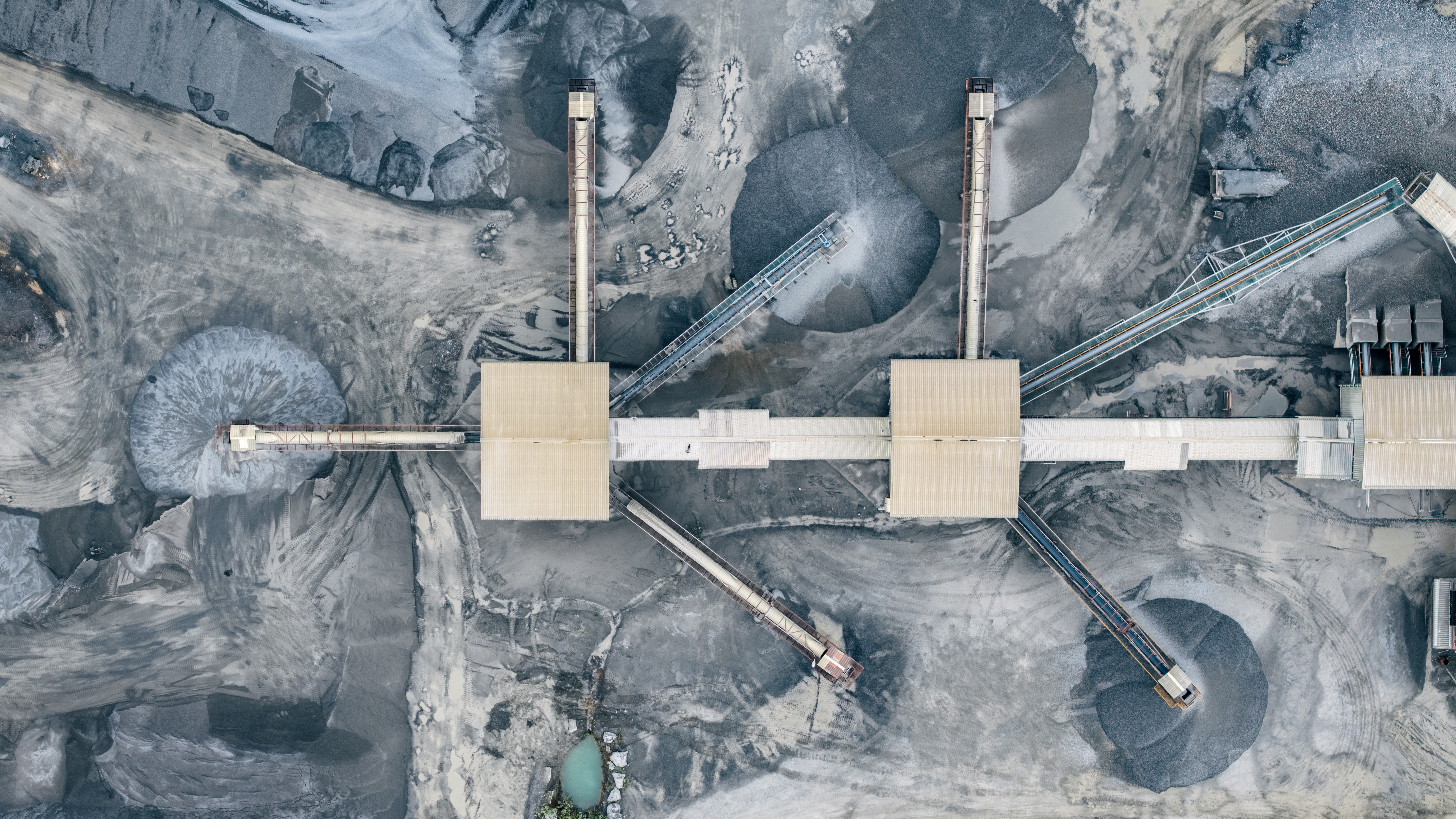 Aerial view of an industrial material processing facility illustrating environmental impact assessment and data collection for life cycle and carbon footprint analysis.