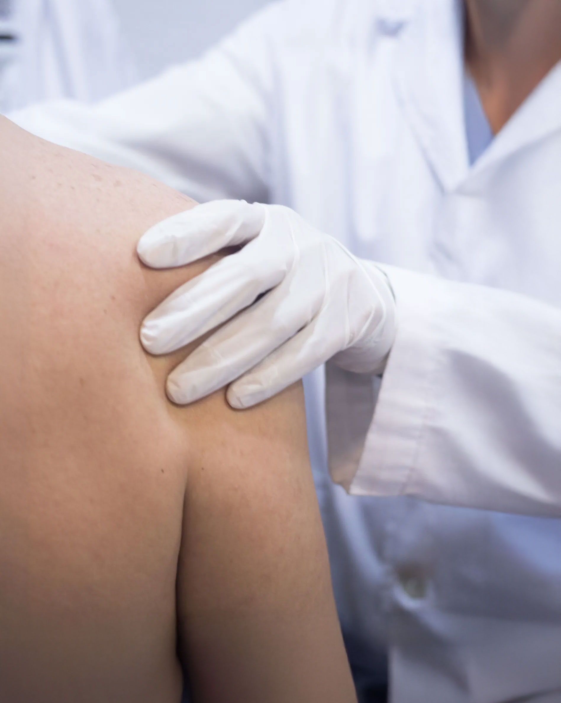 Close-up of a clinician evaluating a patient’s shoulder, representing precise clinical assessment and quality improvement in shoulder surgery programs
