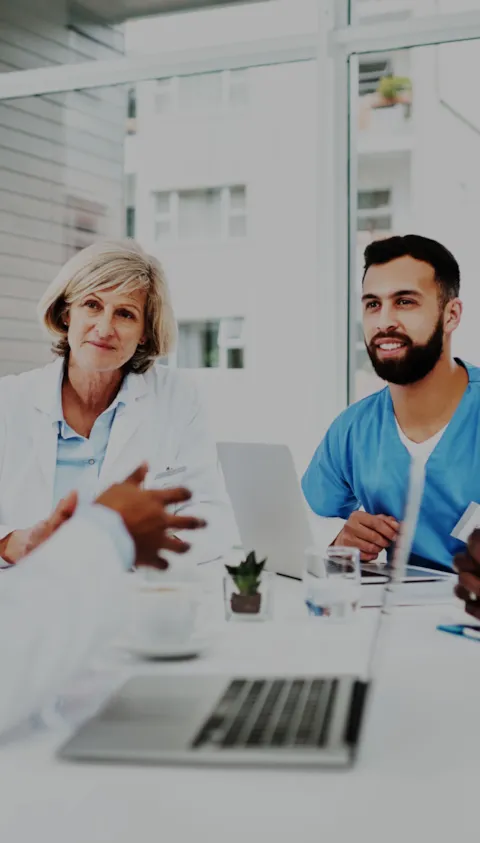 Healthcare professionals reviewing accreditation documents in a hospital corridor, symbolizing DNV’s commitment to quality and patient safety