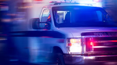 Ambulance vehicle outside a healthcare facility, symbolizing safety, readiness, and quality in ambulatory surgical care.