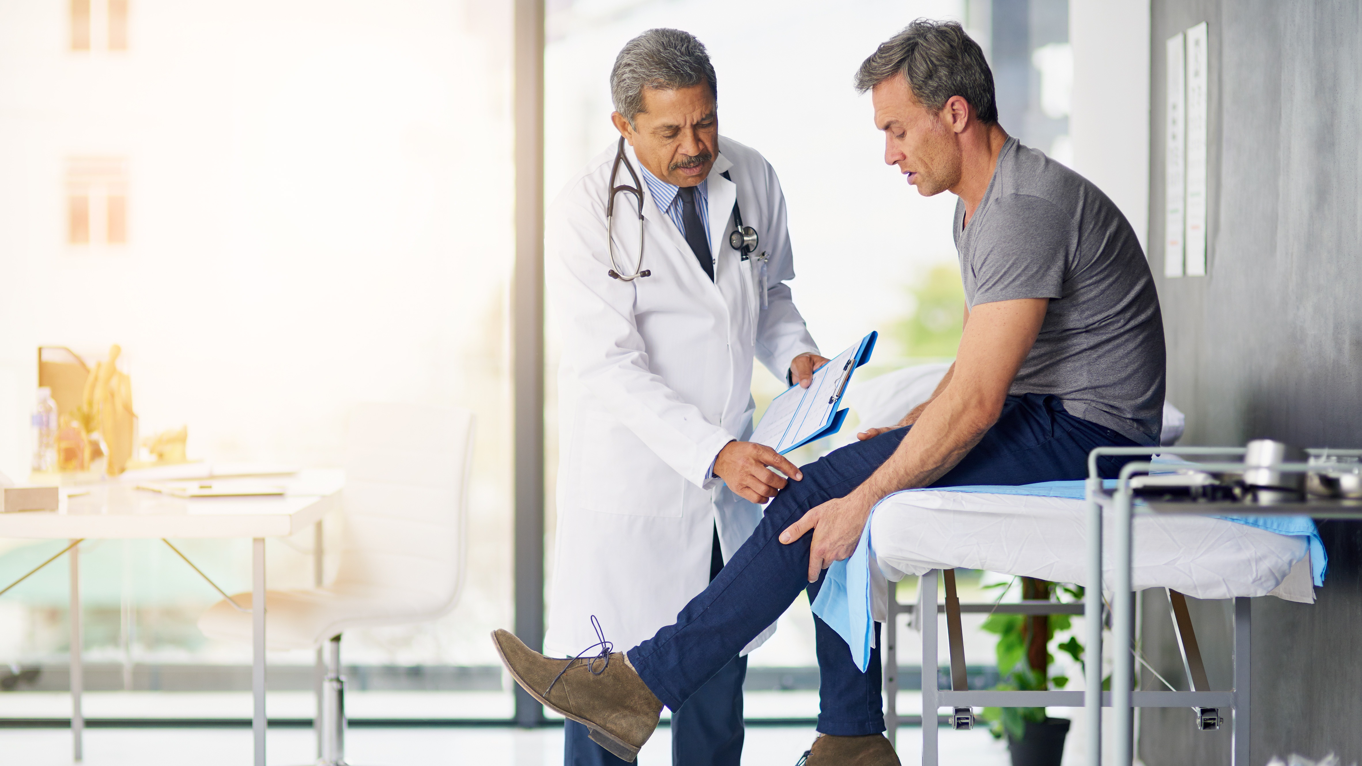 Orthopedic surgeon consulting with a patient after hip or knee surgery, symbolizing trust, recovery, and clinical excellence in joint replacement care.