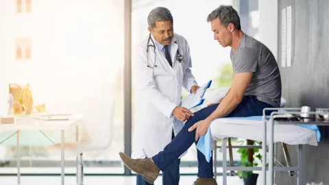 Orthopedic surgeon consulting with a patient after hip or knee surgery, symbolizing trust, recovery, and clinical excellence in joint replacement care.