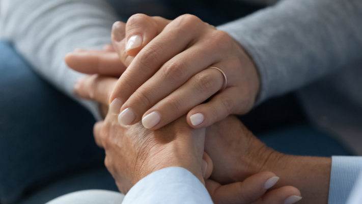 Close-up of a healthcare professional holding a patient’s hands, symbolizing trust, compassion, and DNV’s commitment to heart failure care excellence.