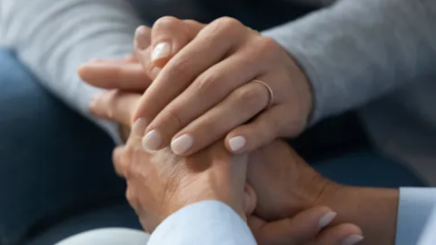 Close-up of a healthcare professional holding a patient’s hands, symbolizing trust, compassion, and DNV’s commitment to heart failure care excellence.