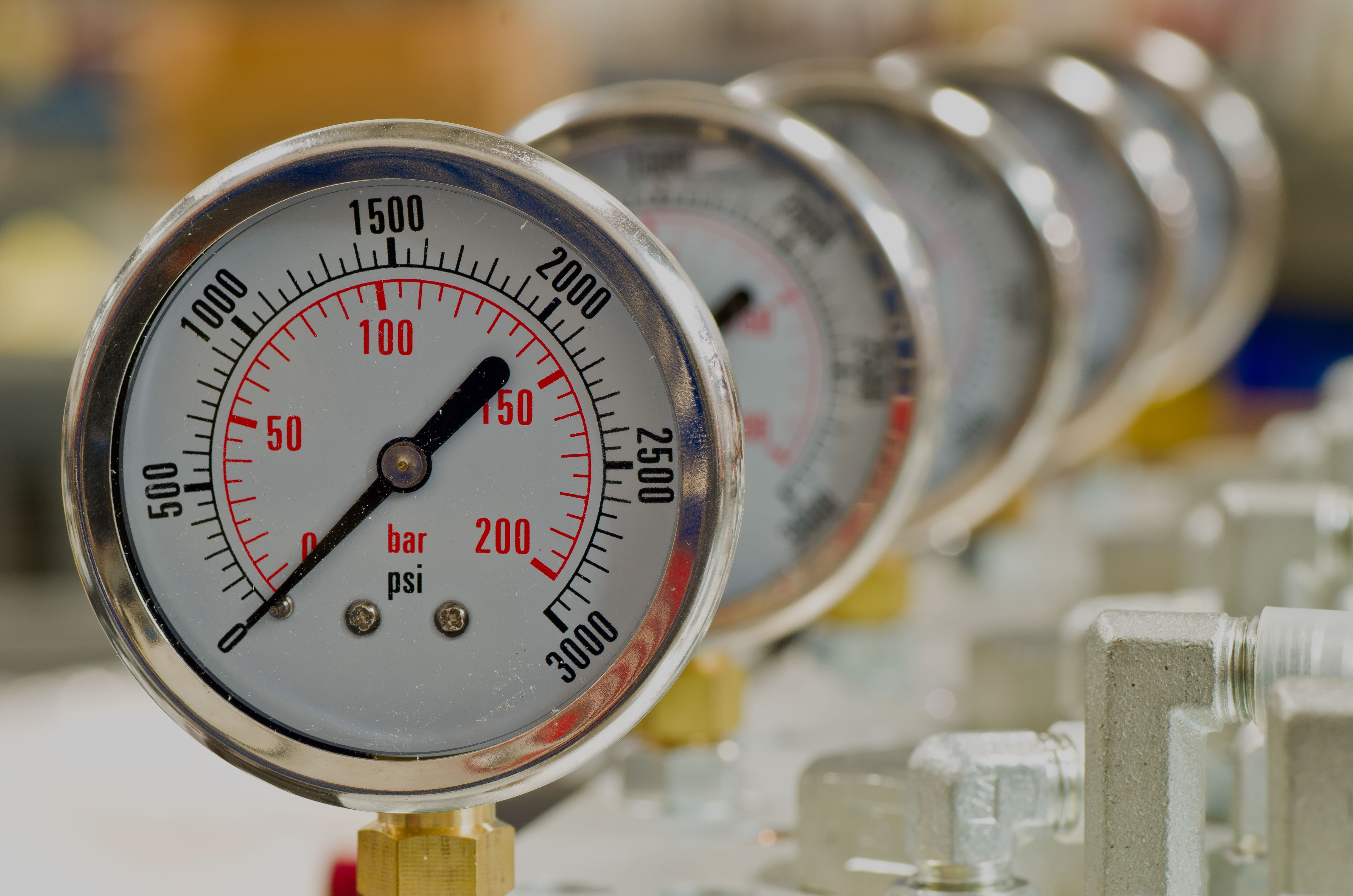Close-up view of pressure gauges on industrial piping, showing high-pressure readings and illustrating pressure equipment monitoring and testing