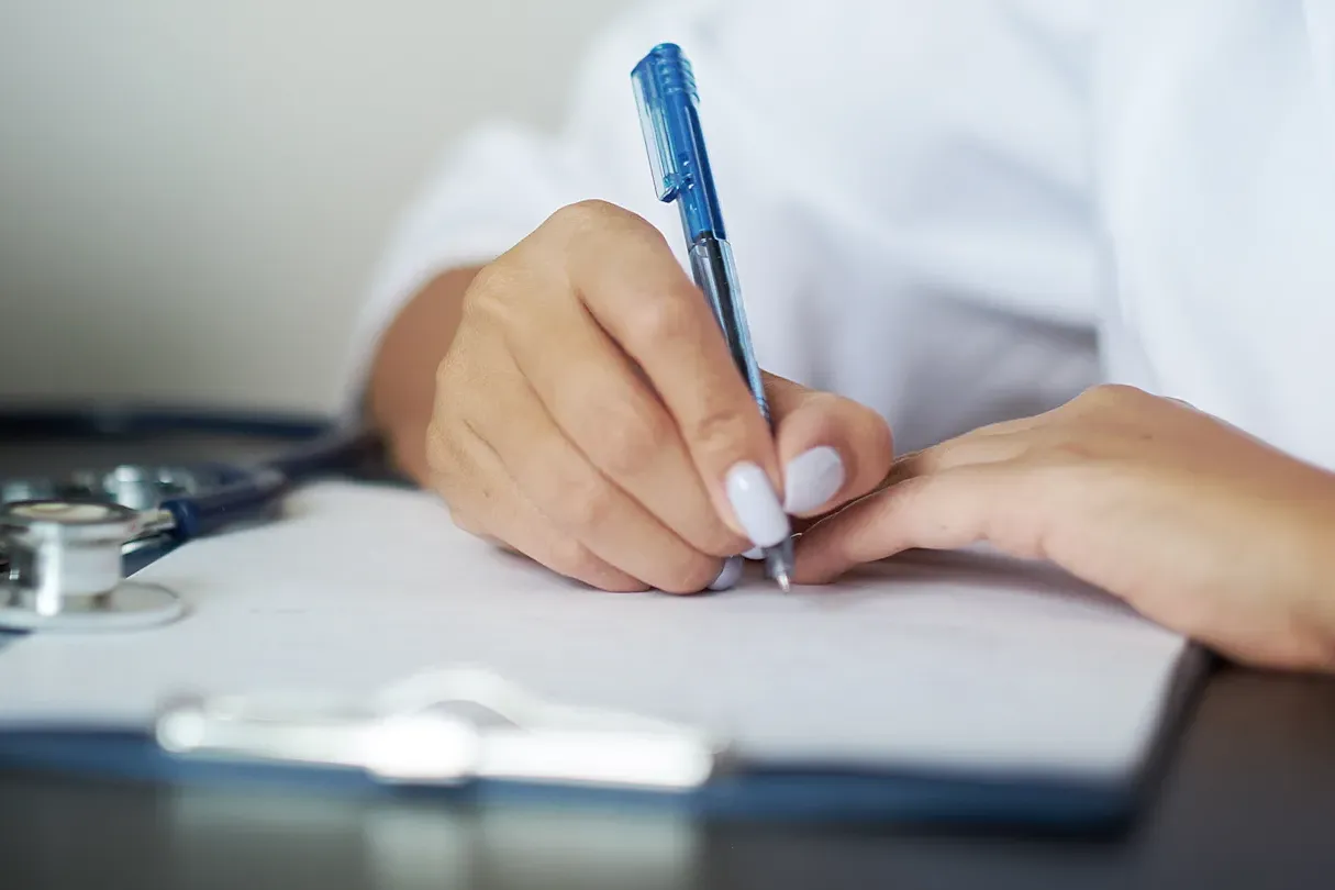 Healthcare professional completing regulatory compliance documentation, representing MDSAP audit preparation and quality management processes