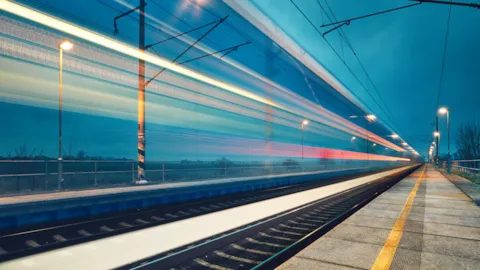 High-speed train on modern rail infrastructure at dusk, representing secure digital rail operations and cybersecurity resilience.