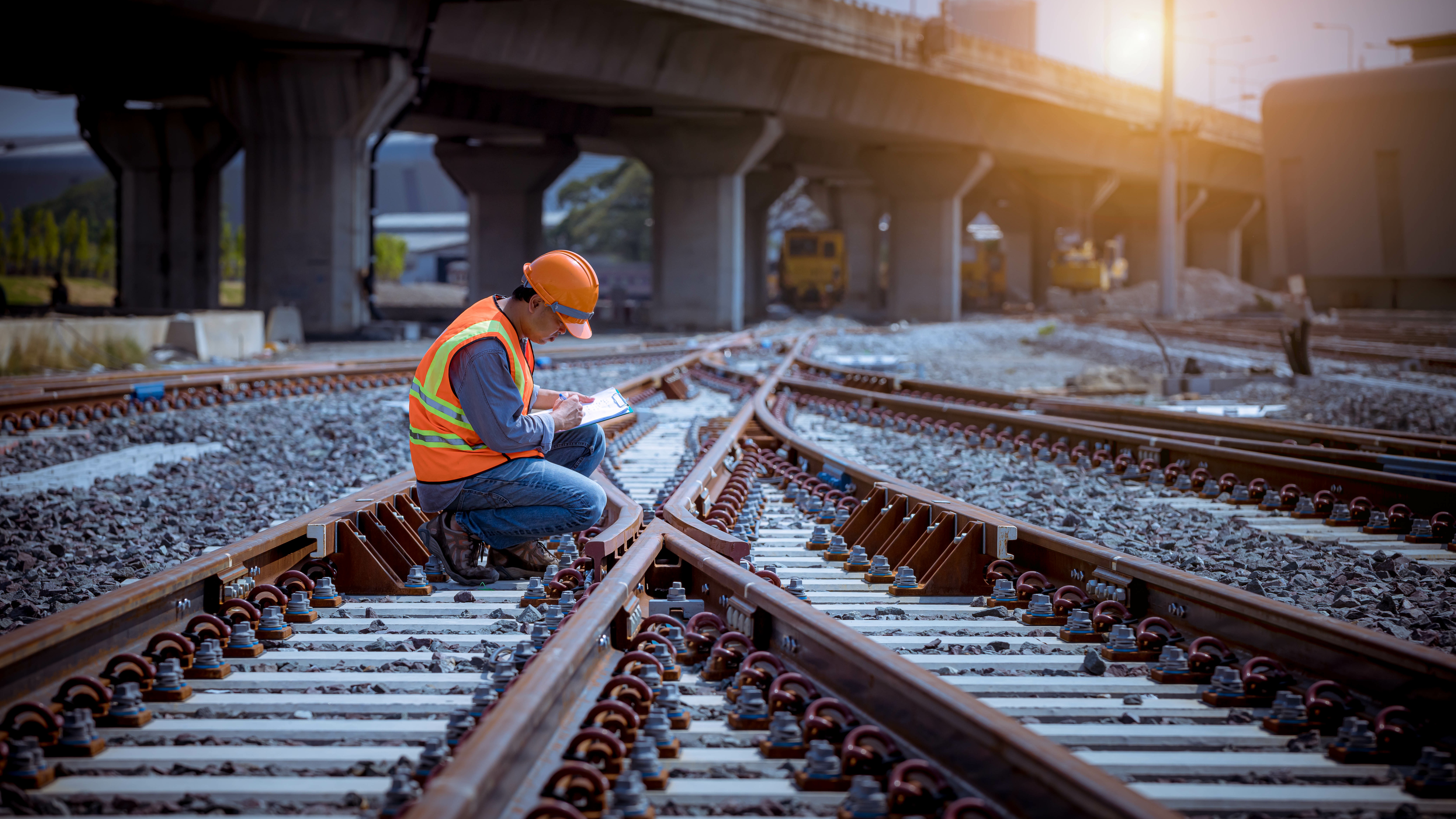 Rail inspector reviewing track components during maintenance work, ensuring compliance and operational safety in railway infrastructure.