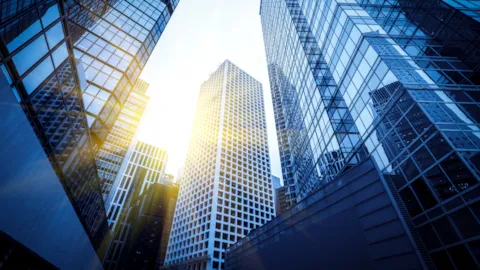 Glass skyscrapers reflecting the sky, symbolizing finance, transparency, and corporate ESG accountability.