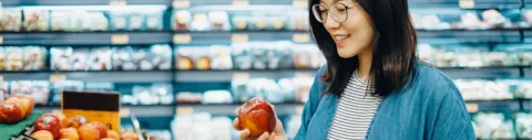 Woman picking fruit in grocery store