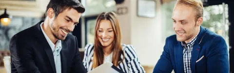 Grupp unga människor samlade runt en iPad