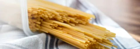 Pile of raw thin spaghetti in plastic container